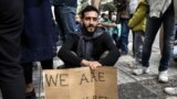تحصن ایرانیان مهاجر مقابل ساختمان وزارت خارجه یونان. یکی از تحصن کنندگان در آتن با در دست داشتن پلاکاردی که روی آن نوشته شده &laquo;ما هم بشریم&raquo; خواستار رسیدگی به تقاصای پناهندگی است.