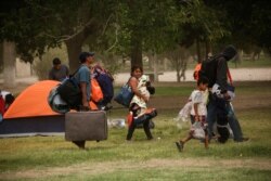 Mexicans camping near the Cordova-Americas international border crossing bridge while waiting to apply for asylum to the U.S., gather their belongings as they are moved to a shelter due a storm forecast, in Ciudad Juarez, Sept. 30, 2019.