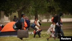 Mexicans camping near the Cordova-Americas international border crossing bridge while waiting to apply for asylum to the U.S., gather their belongings as they are moved to a shelter due a storm forecast, in Ciudad Juarez, Sept. 30, 2019.