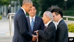 U.S. President Barack Obama, left, shakes hands and chats with Sunao Tsuboi, second right, a survivor of the 1945 atomic bombing and chairman of the Hiroshima Prefectural Confederation of A-bomb Sufferers Organization (HPCASO), as Japanese Prime Minister Shinzo Abe watches them during his visit to Hiroshima Peace Memorial Park in Hiroshima, western Japan, Friday, May 27, 2016. Obama on Friday became the first sitting U.S. president to visit the site of the world's first atomic bomb attack, bringing global attention both to survivors and to his unfulfilled vision of a world without nuclear weapons. (Kimimasa Mayama/Pool Photo via AP) 