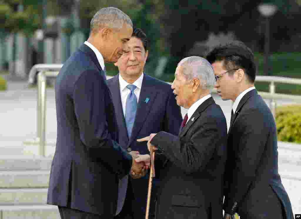 Presiden AS Barack Obama (kiri) berjabat tangan dan berbincang dengan Sunao Tsuboi (kedua dari kanan), penyintas pemboman atom tahun 1945 dan ketua organisasi penyintas bom atom Hiroshima, disaksikan Perdana Menteri Jepang Shinzo Abe (27/5).&nbsp;