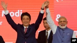 Perdana Menteri Jepang Shinzo Abe (kiri) dan PM India Narendra Modi pada acara peresmian proyek kereta supercepat pertama India di kota Ahmedabad, India barat, Kamis (14/9). 