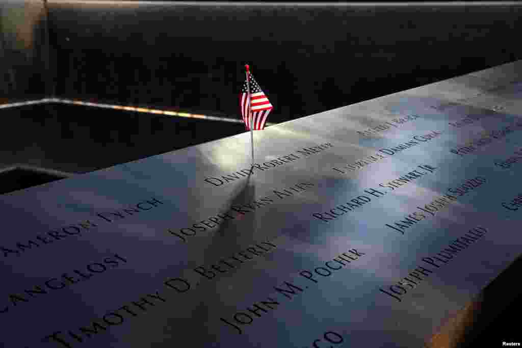 An American flag is seen in the engraved names of 9/11 victims that sits on the edge of the north reflecting pool at the 9/11 Memorial in lower Manhattan, New York, Sept. 11, 2019.