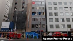17일 일본 오사카 소방대원들이 시내 빌딩 4층에서 발생한 화재를 진압한 뒤 현장을 살피고 있다.