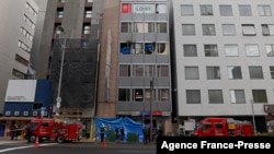 Firetrucks are seen in front of an office building, where a fire broke out in Osaka, Japan, on Dec. 17, 2021. 