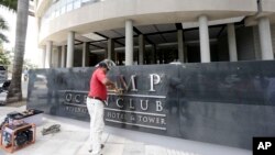 A man removes the word Trump, off a marquee outside the Trump Ocean Club International Hotel and Tower in Panama City, March 5, 2018. 