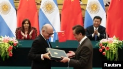 Argentinian President Cristina Fernandez de Kirchner and Chinese President Xi Jinping applaud as Argentinian Foreign Minister Hector Timerman, left, and Chinese Foreign Minister Wang Yi exchange documents Feb. 4, 2015.
