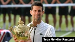 Novak Đoković sa vimbldonskim peharom posle istorijskog meča sa Švajcarcem Rodžerom Federerom (Foto: Reuters/Toby Melville)