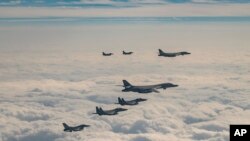 U.S., South Korean and Japanese planes fly over South Korea's southern island of Jeju Dec. 20, 2023. The United States flew a long-range bomber for joint drills with South Korea and Japan on Wednesday in a show of force against North Korea. (South Korea Defense Ministry via AP)