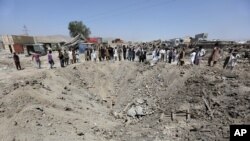 Des Afghans regardent un cratère causé par le bombardement d'un camion, à Kaboul, en Afghanistan, lundi 1 août 2016. (AP Photos/Rahmat Gul)