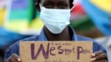 A civilian holds a placard as he celebrates the signing of peace agreement between the Sudan's transitional government and Sudanese revolutionary movements to end decades-old conflict, in Juba, South Sudan, Oct. 3, 2020.