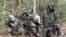 FILE - U.S. Marines take a break during an obstacle course exercise wearing protective chemical, biological gear at Camp Geiger, North Carolina, Nov. 1, 2001.