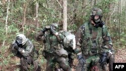 Soldados de la Infantería de Marina de EE.UU. durante un ejercicio de obstáculos con trajes de protección contra sustancias químicas y biológicas en Camp Geiger, Carolina del Norte, Nov. 1, 2001.