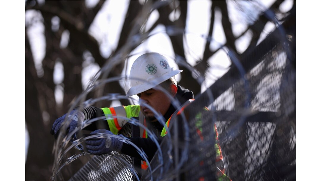 A worker installs razor wire on fencing in front of the U.S. Capitol as an extra security measure in Washington, Jan. 18, 2021.