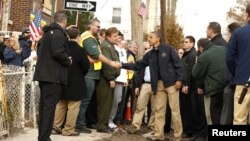 美國總統奧巴馬視察了紐約遭受桑迪颶風重創的一些地區﹐和一名史丹頓島的居民握手