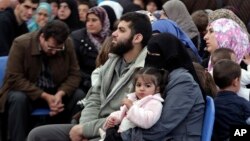 Syrian families await their turn to register at the United Nations High Commissioner for Refugees (UNHCR) center in the northern city of Tripoli, Lebanon, April 3, 2014.