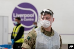 A member of the armed forces waits to test local residents at the Liverpool Tennis Centre on the first day of mass testing pilot, in Liverpool, Britain, Nov. 6, 2020.