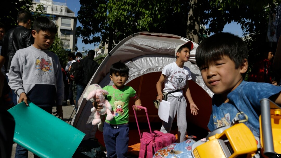 Anak-anak pengungsi membawa mainan dan tas di Lapangan Victoria di Athena, Yunani (1/10). 