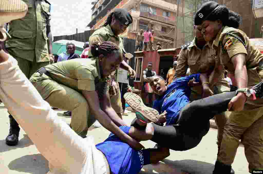 Ugandan police officers detain activists protesting the continued imprisonment of four-time presidential aspirant Kizza Besigye and other political prisoners, in Kampala.