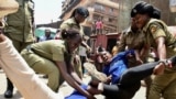 Ugandan police officers detain activists protesting the continued imprisonment of four-time presidential aspirant Kizza Besigye and other political prisoners, in Kampala, Feb. 17, 2025. 