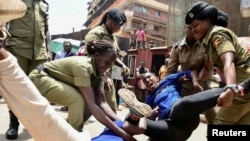 Ugandan police officers detain activists protesting the continued imprisonment of four-time presidential aspirant Kizza Besigye and other political prisoners, in Kampala.