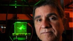 University of Arizona scientist Nasser Peyghambarian
stands in front of his holographic display