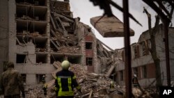Пожежники працюють біля будівлі, зруйнованої внаслідок російського ракетного удару в Чернігові, 17 квітня 2024 р. Щонайменше 17 людей загинули в результаті влучання трьох ракет у центральній частині міста. (Фото: AP Photo/Франсіско Секо)