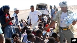 A Yemeni NGO worker distributes water on Somali asylum seekers upon their arrival on the beach of Hasn Beleid village, 230 kms east of the Red Sea port of Aden, (File October 15, 2008).