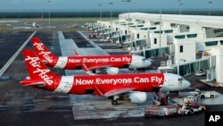 FILE - In this Nov. 10, 2014 photo, AirAsia Airbus A320-200 passenger jets are parked on the tarmac at low cost terminal KLIA2 in Sepang, Malaysia. 