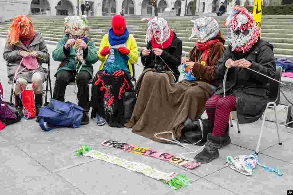 Para anggota Amnesty International di Brussels merajut selendang wol yang merupakan ciri khas Pussy Riot untuk mendukung band punk tersebut (17/2). (AP/Geert Vanden Wijngaert)