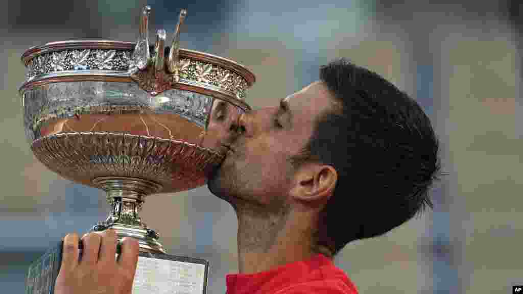 Serbia&#39;s Novak Djokovic kisses the cup after defeating Stefanos Tsitsipas of Greece during their final match of the French Open tennis tournament at the Roland Garros stadium, June 13, 2021 in Paris.