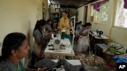 A group of tailors work in a small garage using electric sewing machines at the campus of the Swami Vivekananda Youth Movement, a nongovernmental organization that works to help poor and Indigenous communities, in Kenchanahalli, India, Sept. 23, 2024. 