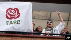 L'ancien chef rebelle Seuxis Hernandez, également connu sous le nom de Jesus Santrich, fait le signe de la victoire depuis un balcon du siège du parti des FARC après avoir été libéré de sa 2nde détention à Bogota, Colombie, le 30 mai 2019.