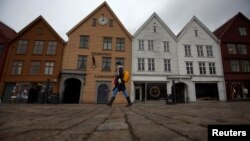 Une femme marche près du port de Bergen, Norvège, le 20 mars 2012.