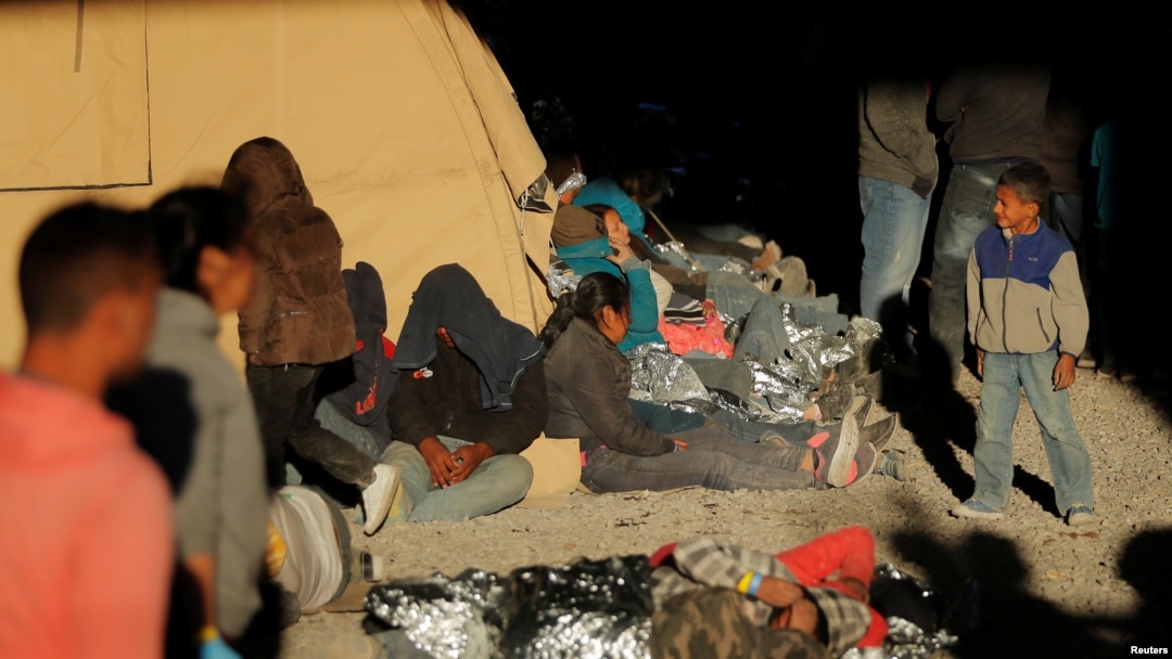 Seorang remaja berjalan dekat para migran yang beristirahat di sebuah tempat penampungan di El Paso, Texas, 29 Maret 2019. Para migran itu ditahan oleh Dinas Bea Cukai dan Perlindungan Perbatasan AS setelah ketahuan menyeberang perbatasan AS-Meksiko secara illegal.