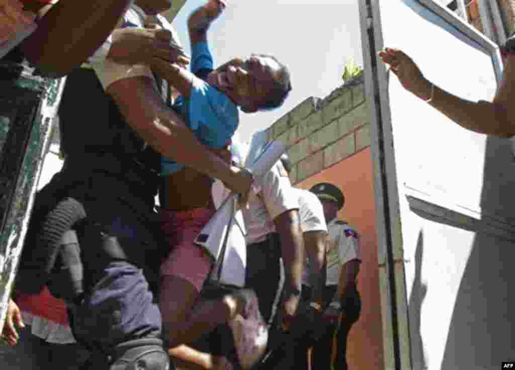 An orphan reacts as she is carried away by a police officer during the closure of the Son of God orphanage in Port-au-Prince, Haiti, Friday, Oct. 21, 2011. The orphanage, whose director was accused by U.S. missionaries of not feeding children and selling