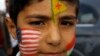 A Kurdish boy has his face painted with the U.S. and the Kurdish flags as he waits to greet Peshmerga fighters near the border town of Suruc, Sanliurfa province October 29, 2014. Iraqi peshmerga fighters arrived in southeastern Turkey on Wednesday en ro