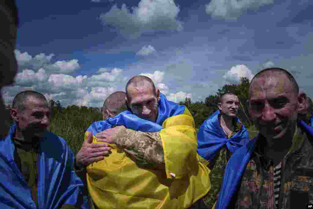 Un militar ucraniano abraza a su camarada después de un intercambio de prisioneros de guerra en la región de Sumy, Ucrania, el 31 de mayo de 2024. (Foto AP/Evgeniy Maloletka)