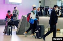 Passengers arrive at LAX from Shanghai, China, after a positive case of the coronavirus was announced in the Orange County suburb of Los Angeles, California, Jan. 26, 2020.