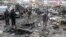 Bystanders look at the the site of a bomb explosion in a crowded part of Pakistan's southwestern city of Quetta, January 10, 2012.