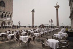 Empty tables sit in St. Mark's square in Venice, Italy. Italy has been scrambling to check the spread of Europe's first major outbreak of coronavirus amid rapidly rising numbers of infections.