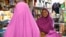 Shukri Abasheikh, owner of Mogadishu Store, speaks with a customer in Lewiston, Maine, Jan. 26, 2016. 