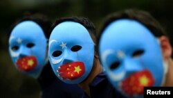 FILE - Activists take part in a protest against China's treatment towards the ethnic Uyghur people and calling for a boycott of the 2022 Winter Olympics in Beijing, at a park Jakarta, Indonesia, Jan. 4, 2022. 