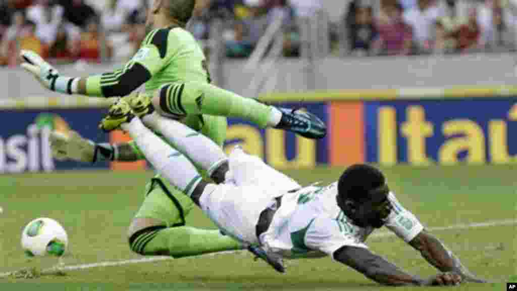 Spain goalkeeper Victor Valdes, back, collides with Nigeria's Joseph Akpala.