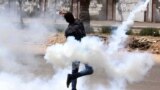 A bystander throws a tear gas canister back at the al-Azhar University campus. The canister was originally shot by the Egyptian security forces towards protesters at the school in Cairo.