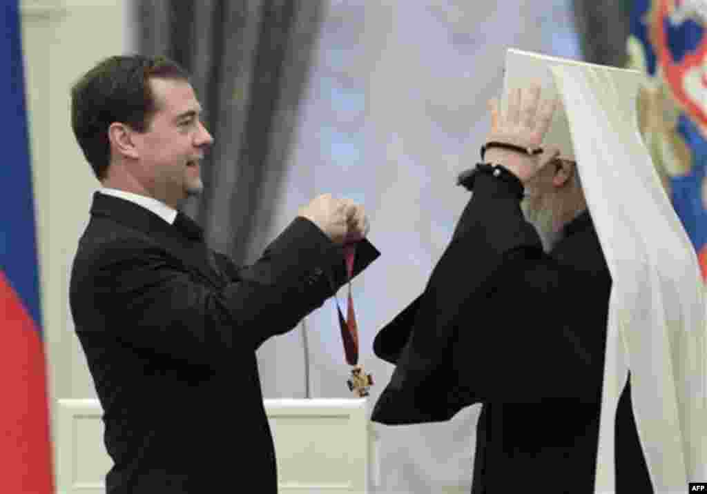 Russian President Dmitry Medvedev presents Supervisor of Moscow Diocese Mitropolitan Juvenaly with a medal during an award ceremony in the Kremlin in Moscow, Thursday, Dec. 30, 2010. (AP Photo/Alexander Natruskin, Pool)