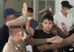 FILE - Thai protest leader Tattep Ruangprapaikitseree flashes a three-finger salute, a symbol of resistance, as he leaves the Samranrat police station for a court appearance in Bangkok, Thailand, Aug, 26, 2020.