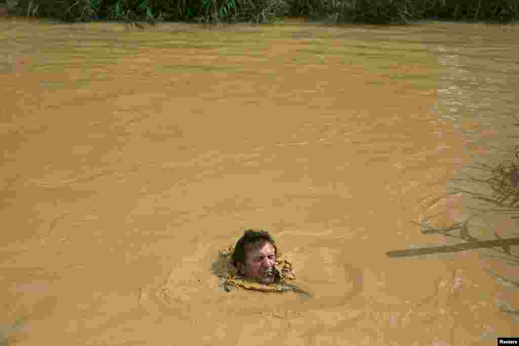 A Christian pilgrim dips in the water at the baptismal site known as Qasr el-Yahud on the banks of the Jordan River, which also acts as a border line near the West Bank city of Jericho. A Christian pilgrim dips in the water at the baptismal site known as Qasr el-Yahud on the banks of the Jordan River, which also acts as a border line near Jordan near the West Bank city of Jericho. 