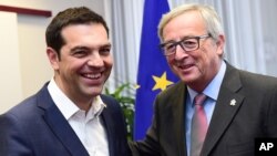 PM Yunani Alexis Tsipras (kiri) bertemu dengan Presiden Komisi Eropa Jean-Claude Juncker di Brussels, hari Kamis (11/6).