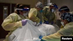 Healthcare personnel rotate a patient who is on a ventilator at a hospital in Hutchinson, Kansas, Nov. 20, 2020.